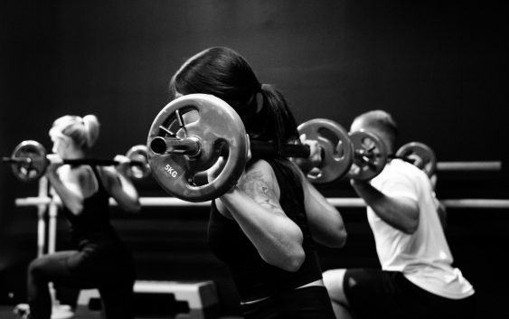 three person lifting barbels